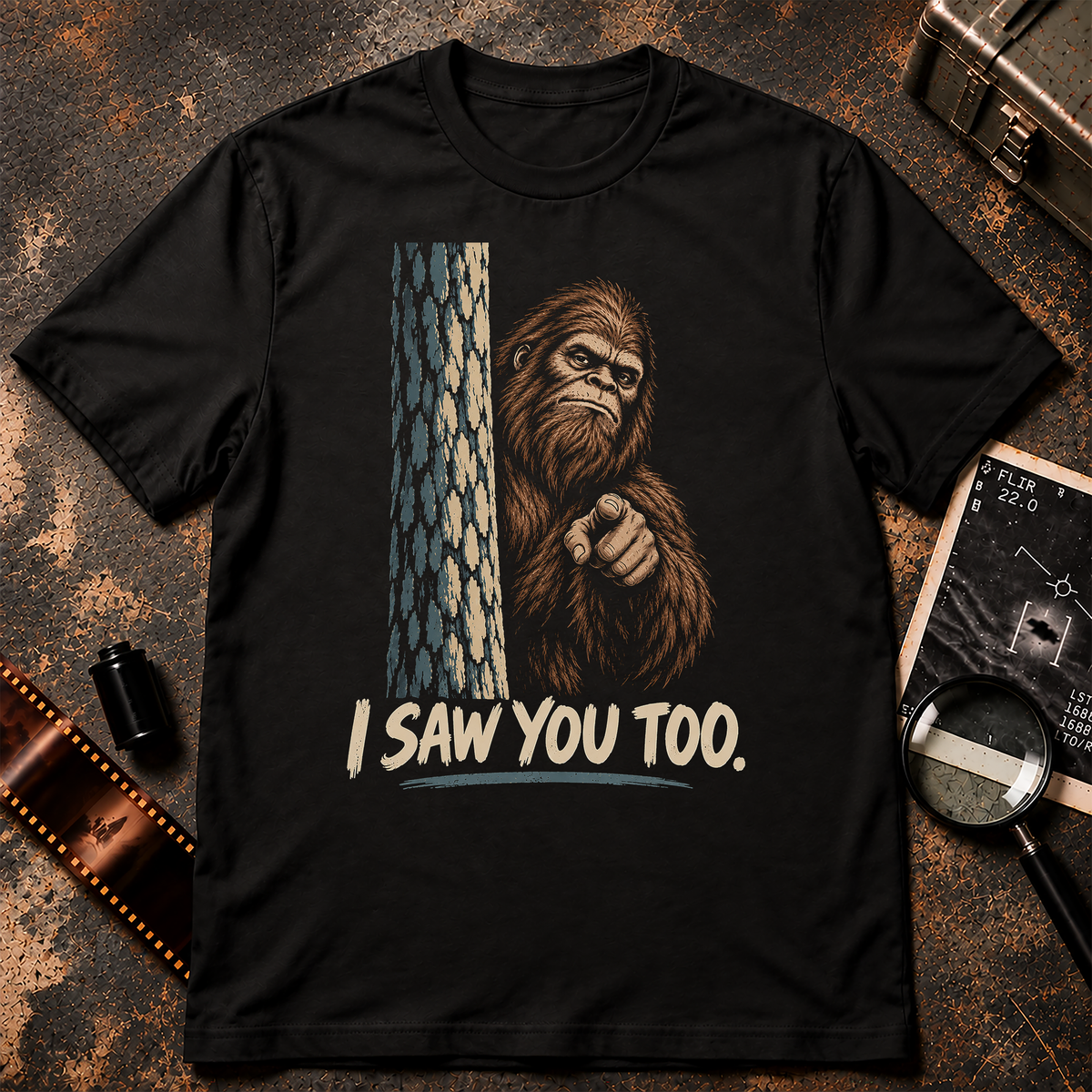 Bigfoot peeking from behind a tree and pointing at the viewer above the words I Saw You Too.