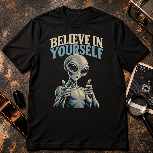 Grey alien giving finger guns beneath retro cream and blue text reading Believe in Yourself on a black background.