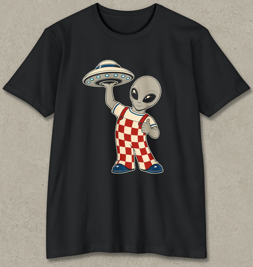 A black short-sleeve crewneck t-shirt featuring a cartoon graphic of a gray alien holding a silver and blue flying saucer, wearing red and white checkered overalls, displayed on a textured gray background.