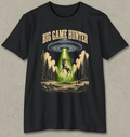 A black short-sleeve graphic t-shirt featuring a 'Big Game Hunter' theme. The graphic shows a green beam from a UFO shining down onto a deer in a forest, with the text 'BIG GAME HUNTER' printed above in a tan serif font.