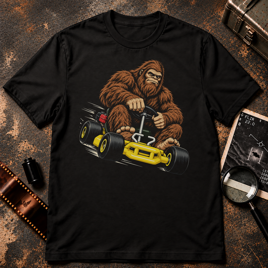Bigfoot racing a bright yellow go-kart with oversized bare feet on the pedals in a retro comic-style shirt design.