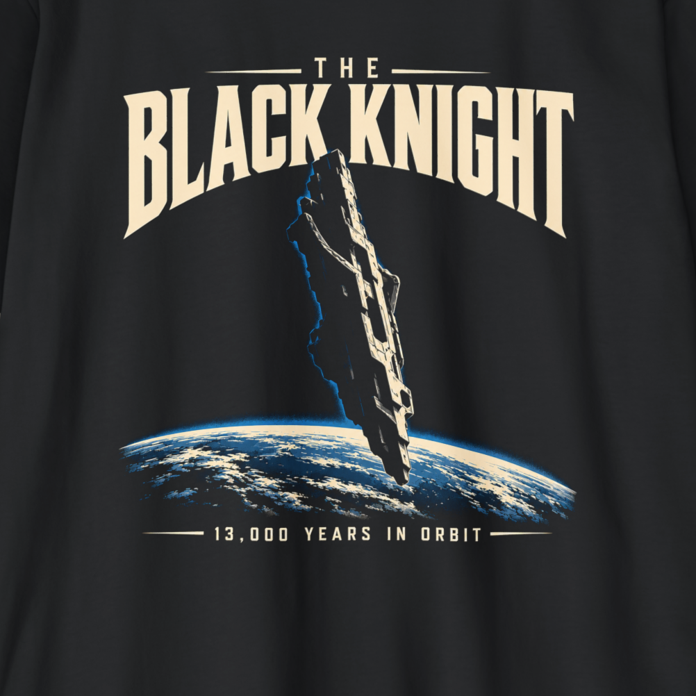 Close-up of a black graphic T-shirt featuring the text 'THE BLACK KNIGHT' above a floating stone shape above Earth, with '13,000 YEARS IN ORBIT' below.