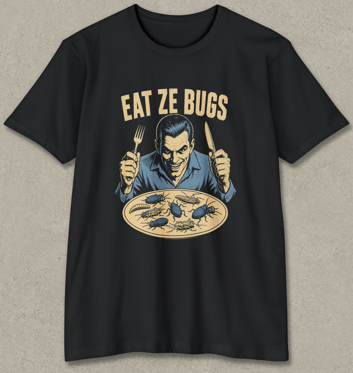 A black short-sleeve graphic t-shirt featuring a retro-style illustration of a man holding a fork and knife over a plate of bugs, with the text 'EAT ZE BUGS' printed above. The t-shirt is displayed flat against a textured gray background.