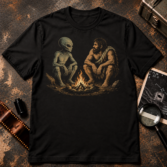Image Alt Text: Retro-style illustration of a grey alien and prehistoric man sitting around a campfire