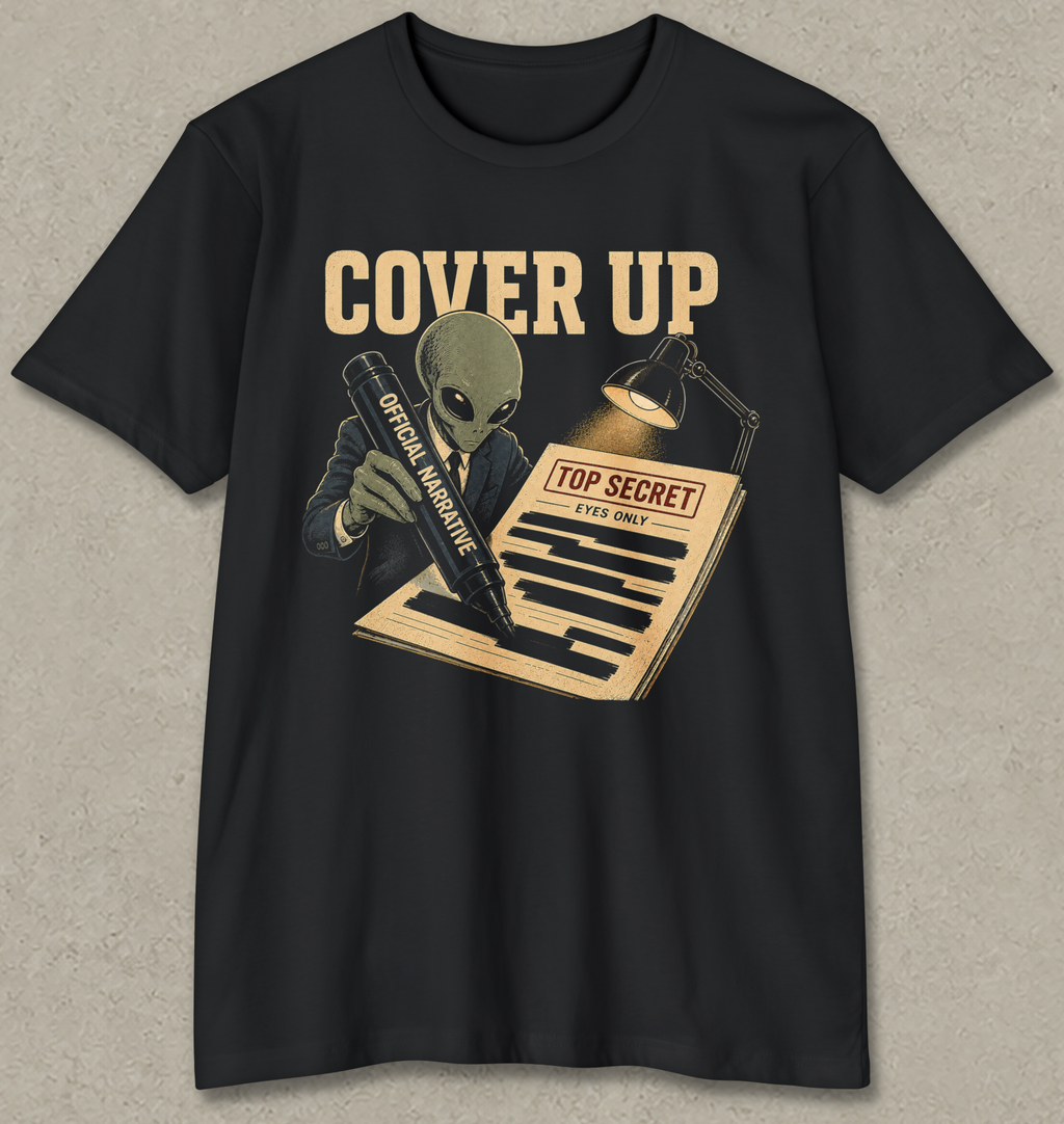 A black short-sleeve crewneck t-shirt with a vintage-style graphic on the front. The graphic features the words 'COVER UP' in beige, an alien in a suit holding a pen labeled 'OFFICIAL NEGATIVE', and a document labeled 'TOP SECRET'.