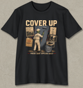 A black short-sleeve crewneck t-shirt with a vintage-style graphic on the front. The graphic features a construction worker painting a wall next to a paint can, with the text 'COVER UP' at the top and 'FRESH COAT APPLIED DAILY' at the bottom.
