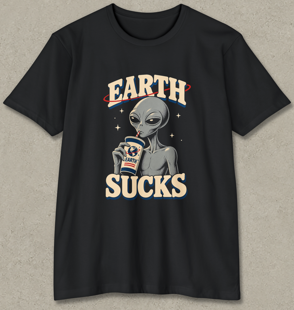 A black short-sleeve graphic t-shirt featuring a retro-style alien holding a coffee cup with 'EARTH' written above and 'SUCKS' below, displayed on a textured gray background.
