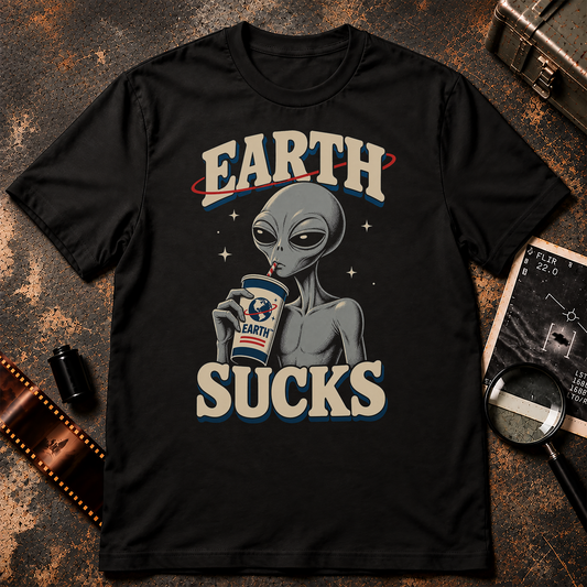 Grey alien sipping from an Earth-branded drink cup beneath bold retro text reading EARTH SUCKS.