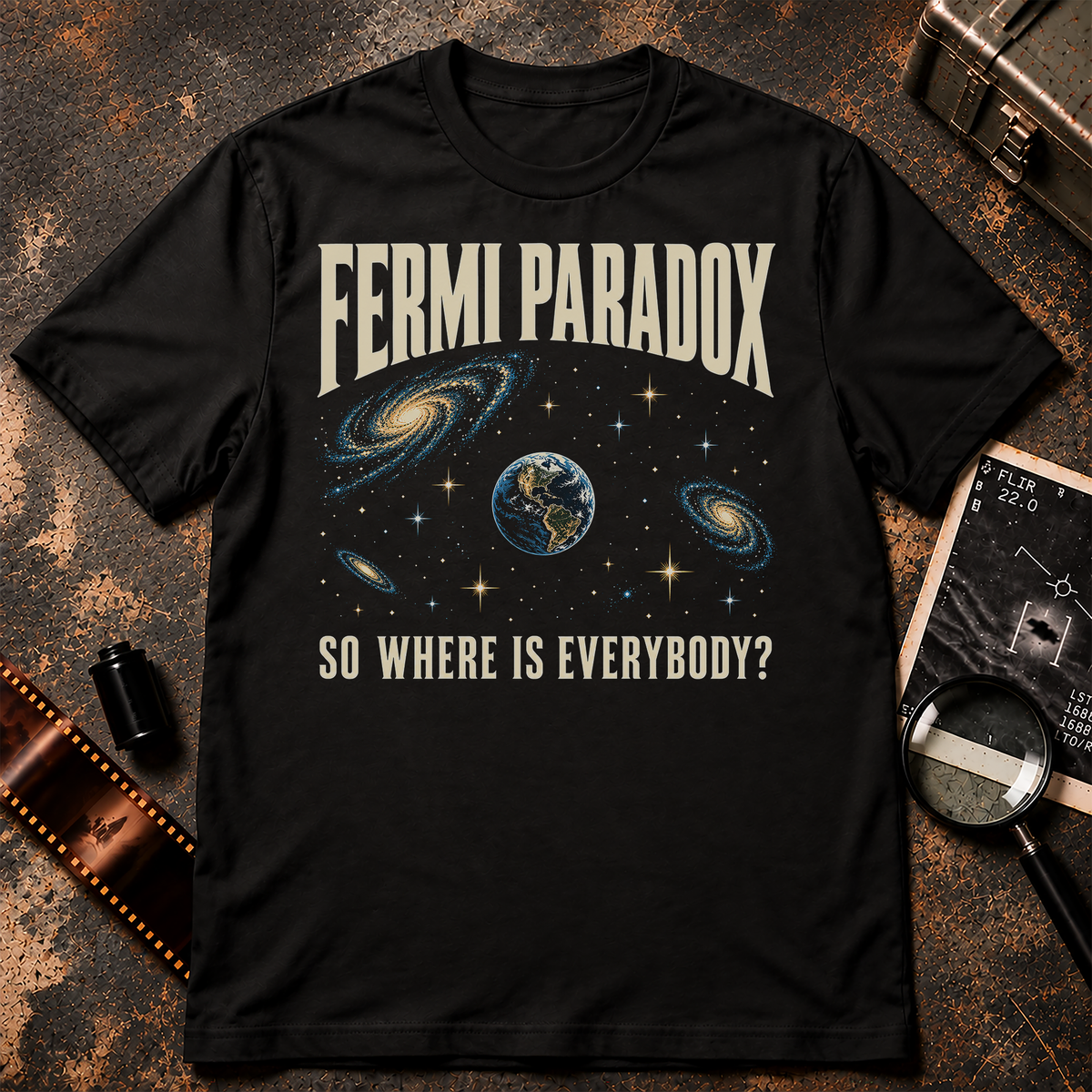 Fermi Paradox shirt design featuring a lonely Earth surrounded by spiral galaxies and stars, with retro cream lettering reading So Where Is Everybody?