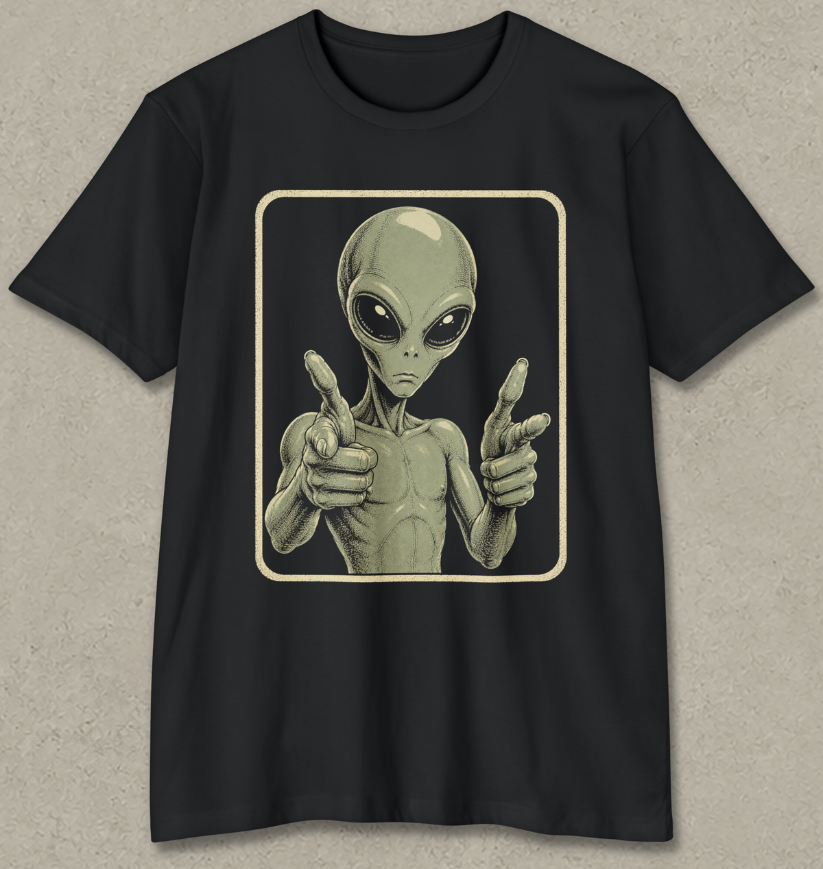 A black short-sleeve crewneck t-shirt featuring a graphic print of a classic alien pointing forward, set against a textured gray background.