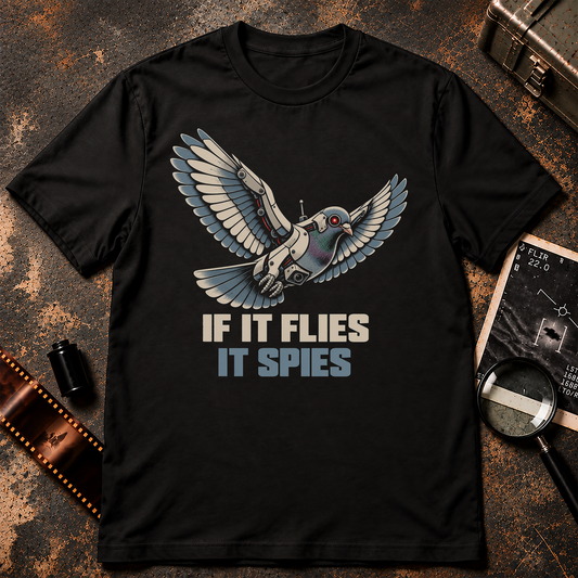 Cybernetic robotic pigeon flying with mechanical wings, a glowing red camera eye, and surveillance equipment above If It Flies It Spies text.