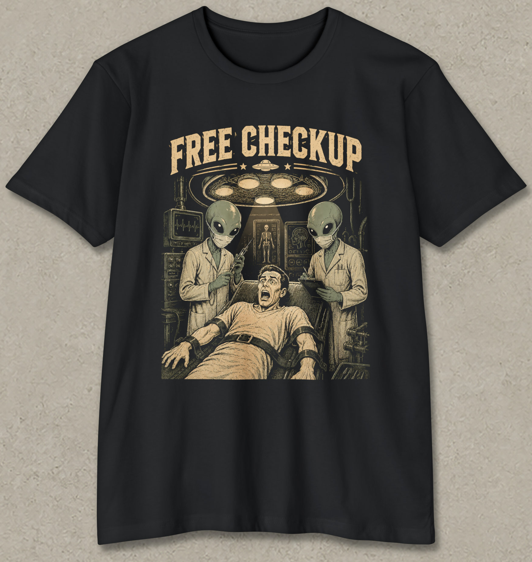 A black short-sleeve crewneck t-shirt with a vintage-style graphic print on the front. The graphic features the text 'FREE CHECKUP' in a distressed beige font above an illustration of a man in a hospital gown surrounded by two green-skinned aliens under a surgical light.