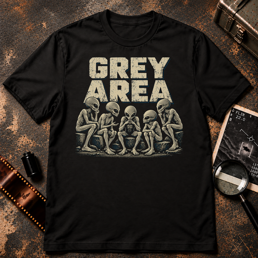 Grey Area T-Shirt design featuring five thoughtful Grey aliens sitting together on stone blocks, appearing to hold a mysterious discussion. Large distressed cream lettering reads GREY AREA above the aliens, with subtle blue accents against a black background.