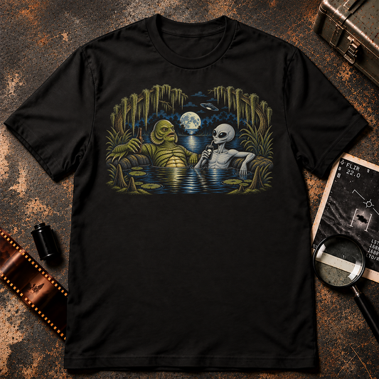 Cryptid Hot Tub shirt design featuring a grey alien and swamp creature relaxing together in a moonlit lagoon with drinks and a UFO overhead.