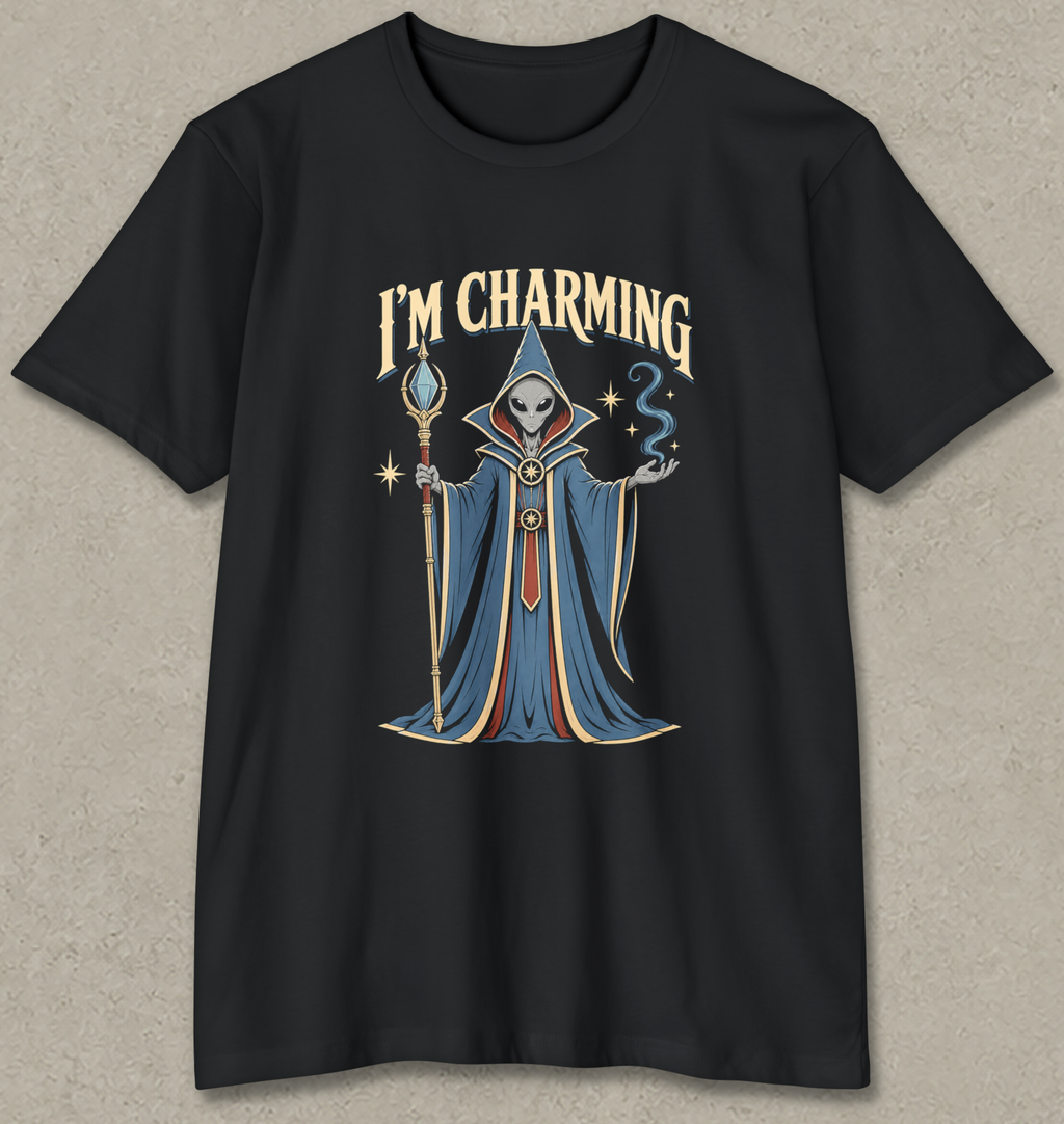 A black short-sleeve crewneck t-shirt featuring a graphic of a hooded wizard with a skull for a head, holding a staff, with the text 'I'M CHARMING' above. The graphic has blue, gold, and white details, set against a textured gray background.