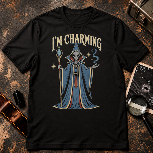 Grey alien dressed as a cosmic wizard holding a staff and conjuring blue magic beneath the words I’M CHARMING.
