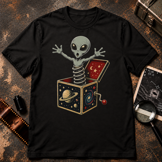 Alien Jack-in-the-Box shirt design featuring a grey alien springing from a vintage space-themed jack-in-the-box decorated with planets and stars.