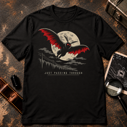 Mothman shirt graphic with red-eyed Mothman flying past a full moon above a dark forest and telephone poles