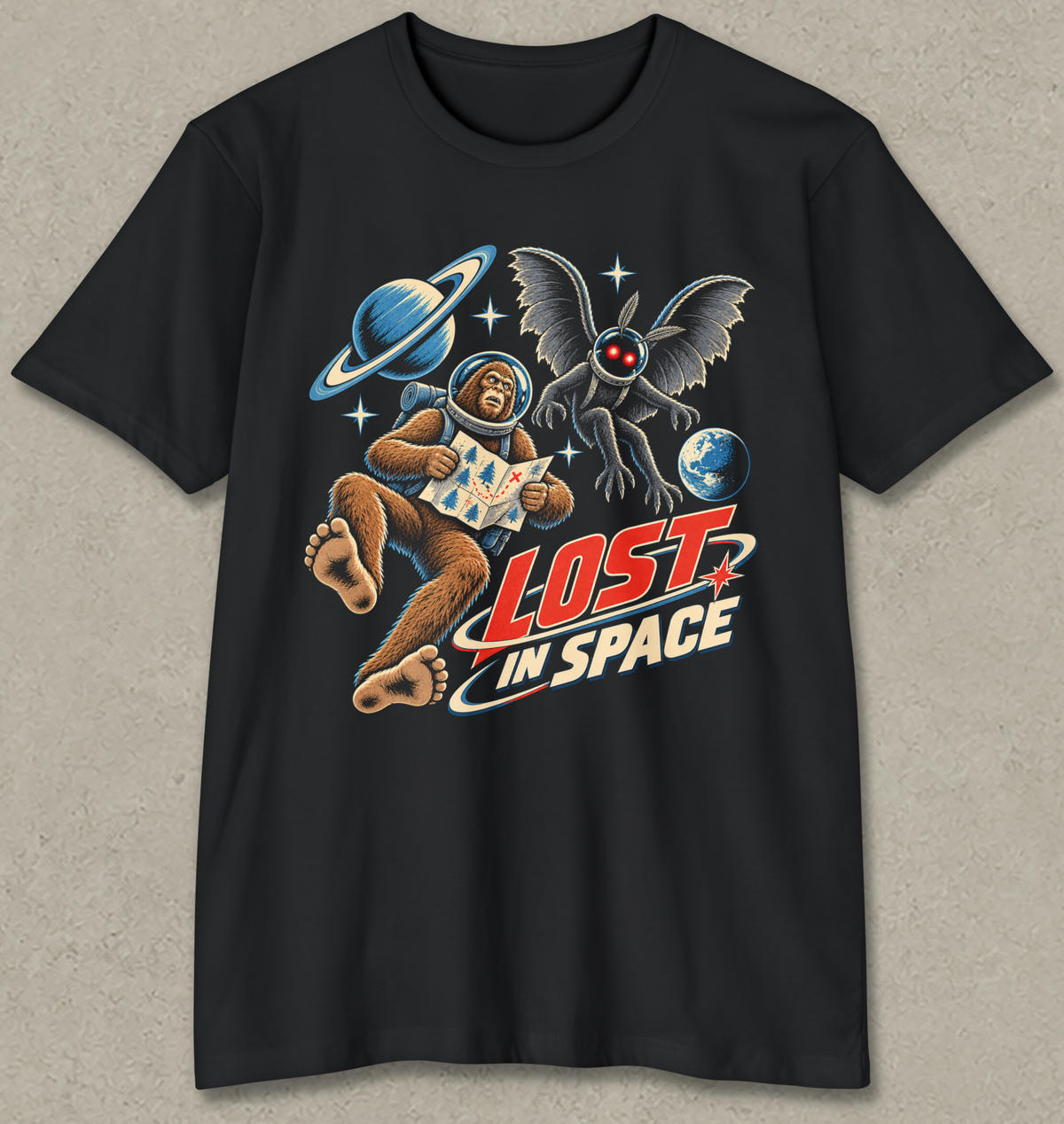 A black short-sleeve crewneck t-shirt featuring a retro-style graphic of a brown ape astronaut floating in space with a ringed planet, a winged creature, and the text 'LOST IN SPACE'.