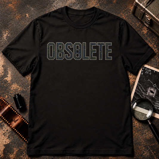 OBSOLETE typography shirt design featuring cream block letters filled with blue and green circuit-board traces and computer chips on a black background.