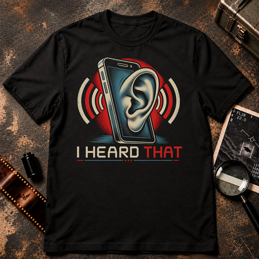 I Heard That phone surveillance graphic t-shirt design featuring a giant human ear emerging from a smartphone screen, surrounded by red and cream sound waves. Vintage comic-style illustration in cream, blue, and red with bold I HEARD THAT lettering on a black background.