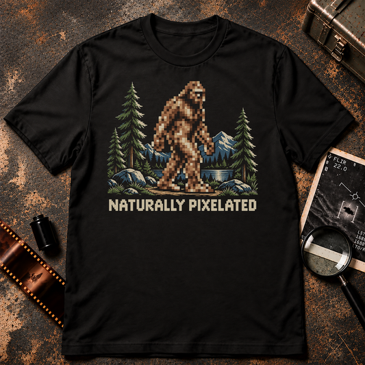 Pixelated Bigfoot walking through a clear mountain forest landscape above the words NATURALLY PIXELATED in a retro pixel font.
