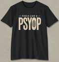 A black short-sleeve crewneck t-shirt with a distressed graphic on the chest that reads 'FEELS LIKE A PSYOP' in beige, with a spiral eye motif inside the letter 'O'. The t-shirt is displayed flat against a textured gray background.