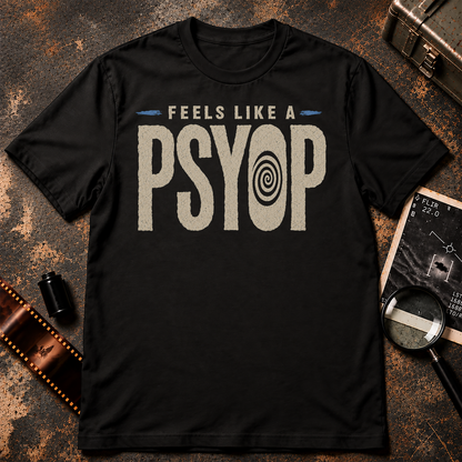 Minimalist conspiracy graphic with distressed cream lettering reading “FEELS LIKE A PSYOP” against a black background. The letter O in PSYOP contains a black hypnotic spiral, with small blue accent marks on either side of the upper text.