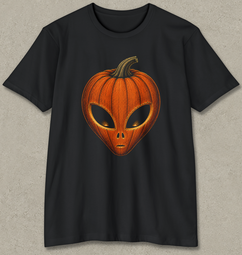A black short-sleeve crewneck t-shirt featuring a graphic of a carved orange pumpkin shaped like an alien head, displayed against a textured gray background.