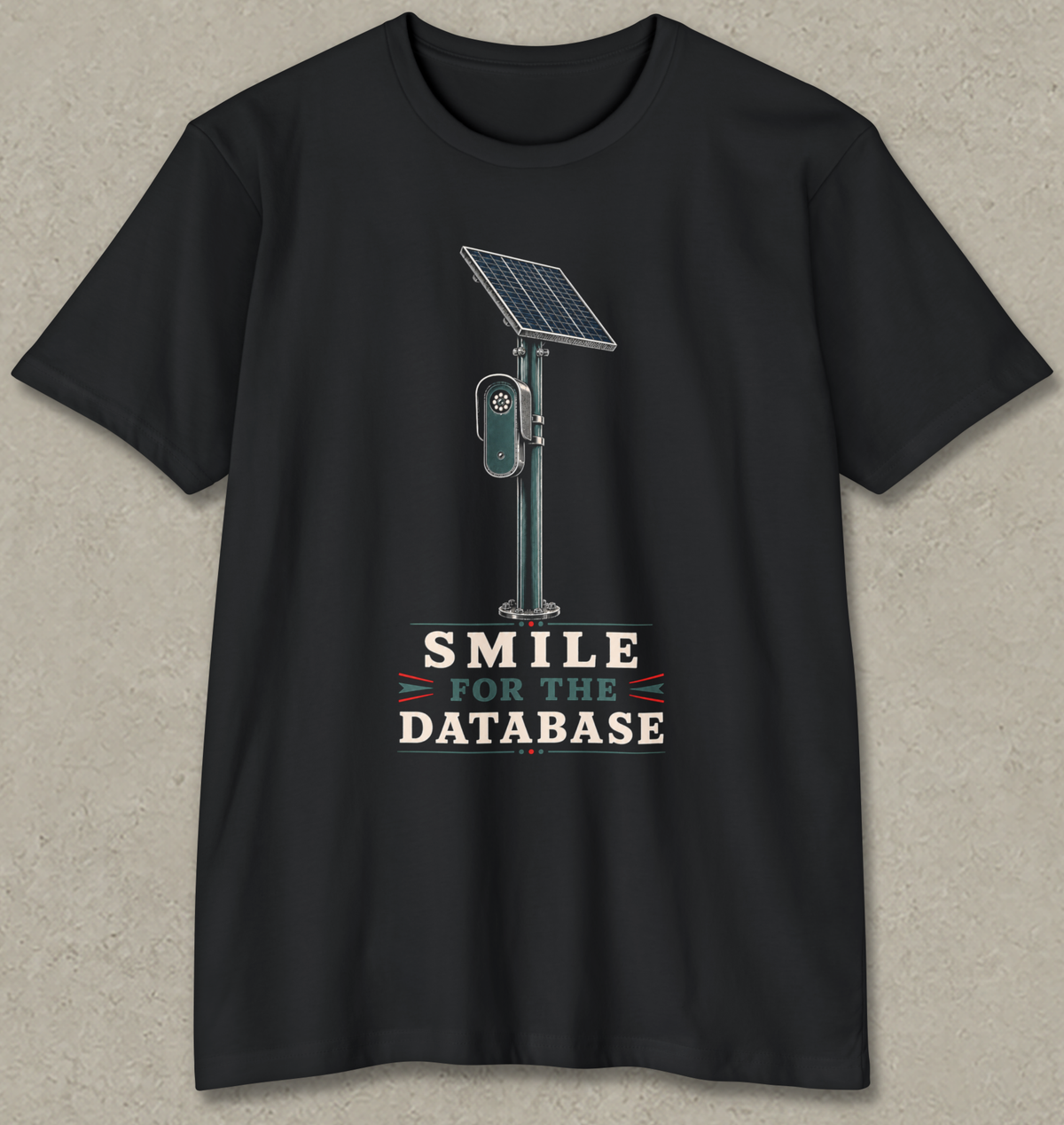 A black short-sleeve crewneck t-shirt with a graphic of a solar-powered parking ticket reader and the text 'SMILE FOR THE DATABASE' printed on the front, displayed against a textured gray background.