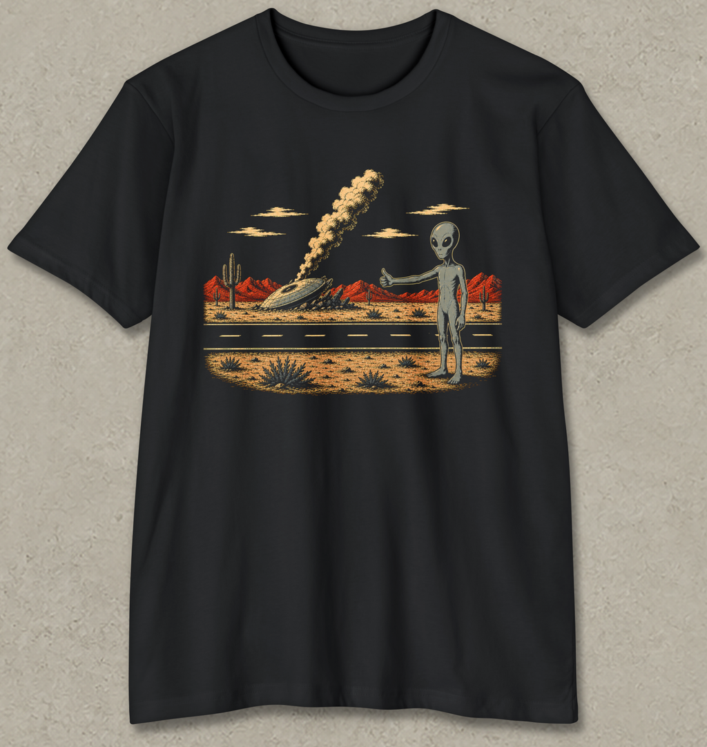 A black short-sleeve crewneck t-shirt with a retro-futuristic graphic print of a gray alien standing in a desert landscape next to a road with an explosion in the distance.