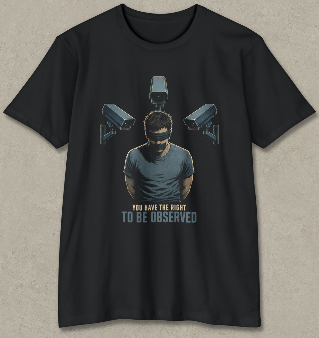 A black short-sleeve t-shirt with a graphic print of a man wearing a blindfold and eyepatch, surrounded by three security cameras, with the text 'YOU HAVE THE RIGHT TO BE OBSERVED' underneath, displayed on a textured gray background.