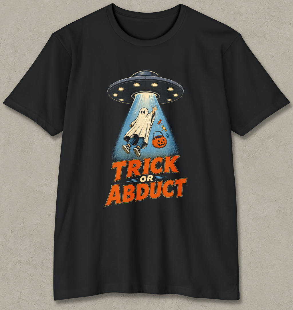 A black short-sleeve crewneck t-shirt with a graphic of a ghost being abducted by a UFO, with the text 'TRICK OR ABDUCT' in orange. The t-shirt is displayed flat against a textured gray background.