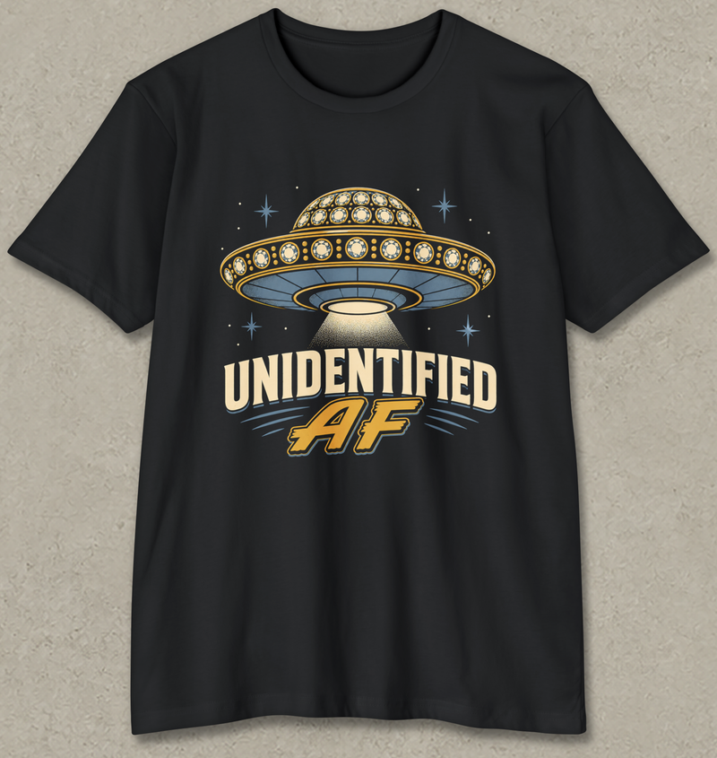 A black short-sleeve t-shirt with a retro-style graphic of a UFO and the text 'UNIDENTIFIED AF' in cream and gold, displayed against a textured gray background.