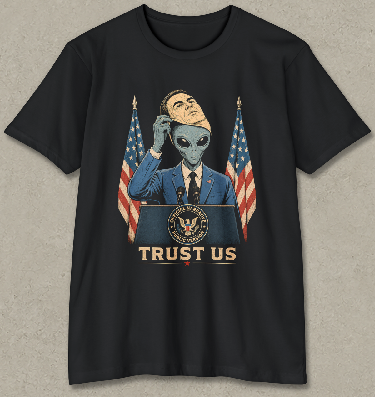 A black short-sleeve t-shirt with a graphic print of an alien in a suit at a podium with American flags and the text 'TRUST US'.