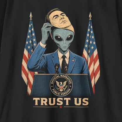 A close-up of a black t-shirt featuring a satirical graphic print of a man in a blue suit with an alien head, standing behind a podium with American flags and the text 'TRUST US'.