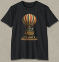 A black short-sleeve crewneck t-shirt featuring a vintage-style graphic of a striped hot air balloon with the text 'IT'S JUST A WEATHER BALLOON' printed below it, displayed flat against a textured gray background.