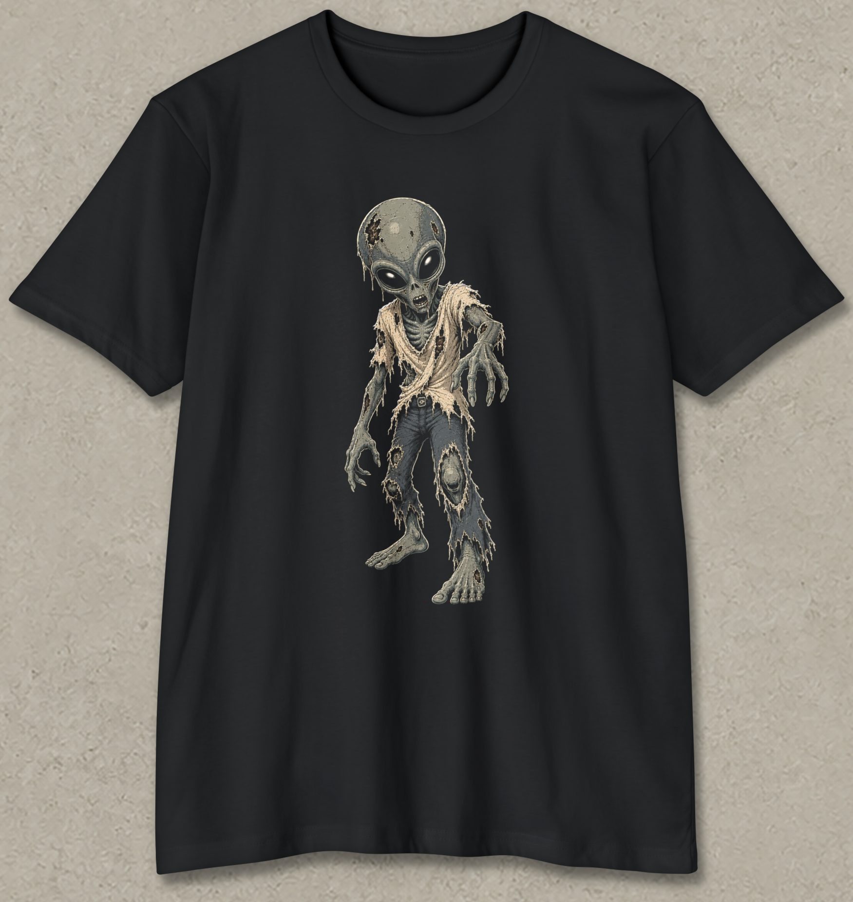A black short-sleeve crewneck t-shirt featuring a graphic print of a distressed, tattered alien standing in the center. The t-shirt is displayed flat against a textured gray background.